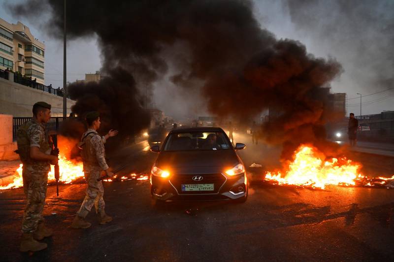 Lebanese soldiers dismantle a burning roadblock set up by anti-government protesters in Beirut. EPA