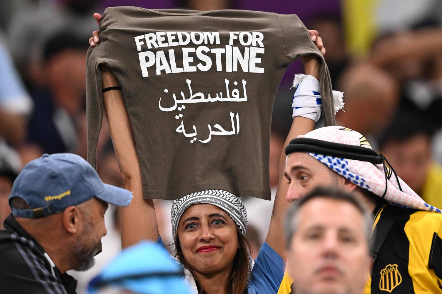 A Uruguay fan holds aloft a T-shirt showing support for Palestine during the match against Portugal at the Lusail Stadium. AFP