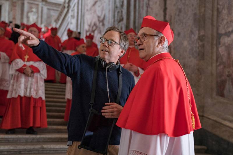 This image released by Netflix shows director Fernando Meirelles, left, and Jonathan Pryce during the filming of "The Two Popes." Pryce was nominated for an Oscar for best actor in a leading role. Co-star Anthony Hopkins also received a nomination for best supporting actor and Anthony McCarten was nominated for best adapted screenplay. (Peter Mountain/Netflix via AP)