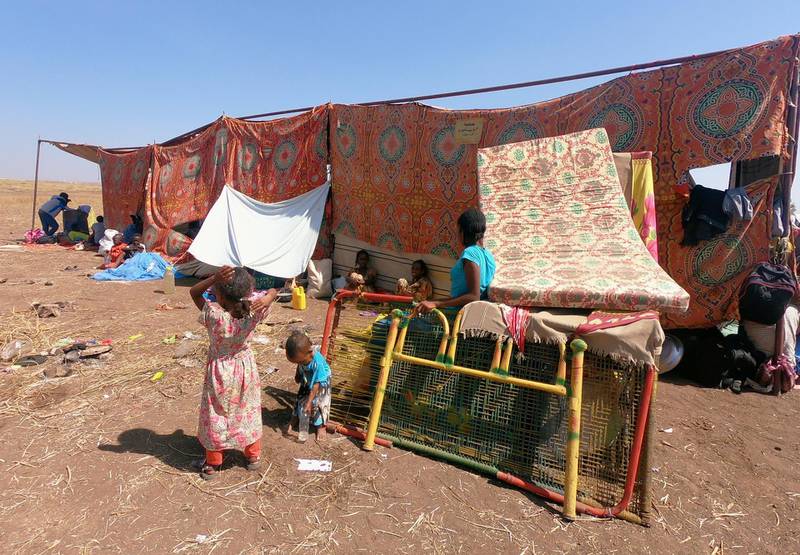 Ethiopians who fled the ongoing fighting in Tigray region, sit with their belongings in Hamdait village on the Sudan-Ethiopia border in eastern Kassala state, Sudan. Reuters