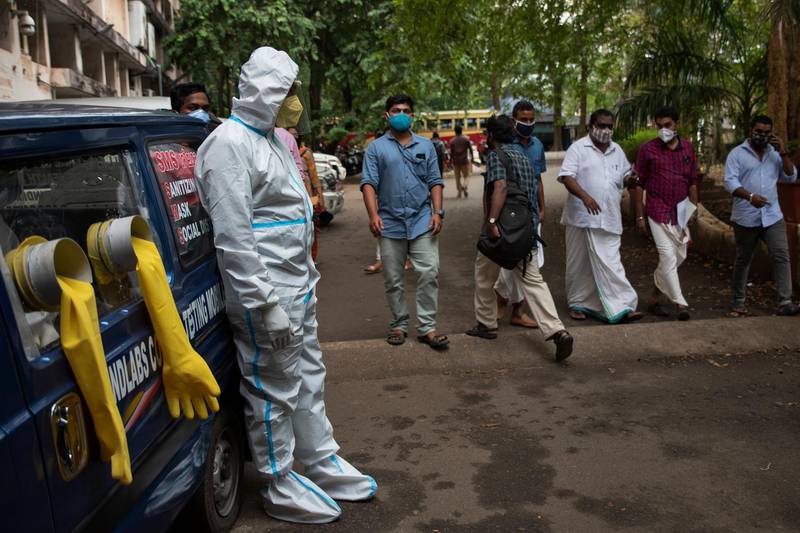 A man in protective suit stands next to a mobile testing kiosk outside the Ernakulam district administration headquarters in Kochi, Kerala, India. AP Photo