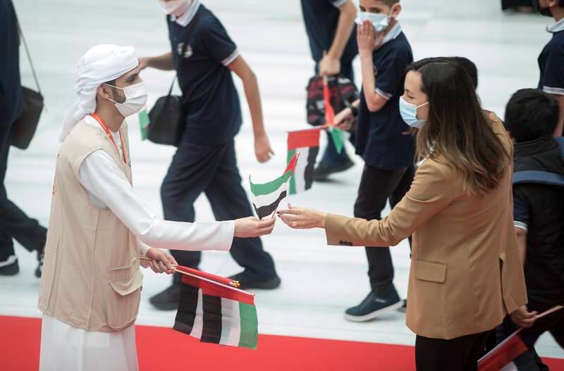 Staff give out UAE flags to celebrate flag day at the Sharjah Book Fair.  Ruel Pableo / The National