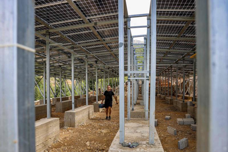 A technician works on the solar panel system installed for the village of Toula in northern Lebanon.