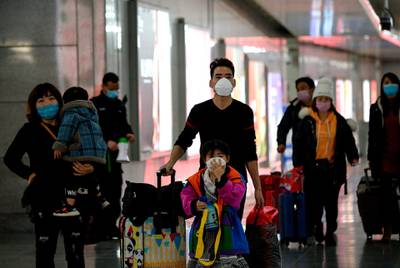 Passengers wearing face masks arriving at Wenzhou railway station in Wenzhou. The National Health Commission on March 1 reported 573 new infections, bringing the total number of cases in mainland China to 79,824. AFP
