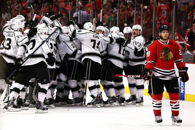 Ben Smith, right, of the Chicago Blackhawks skates away as the Los Angeles Kings celebrate after defeating the Blackhawks 5-4 in overtime in Game 7 to win the Western Conference final of the Stanley Cup play-offs on June 1, 2014, in Chicago, Illinois. Jonathan Daniel / AFP