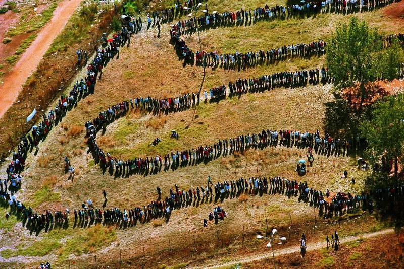 April 27, 1994: A long line of people wait outside the polling station in Soweto to vote in South Africa’s first all-race elections. Denis Farrell / AP Photo