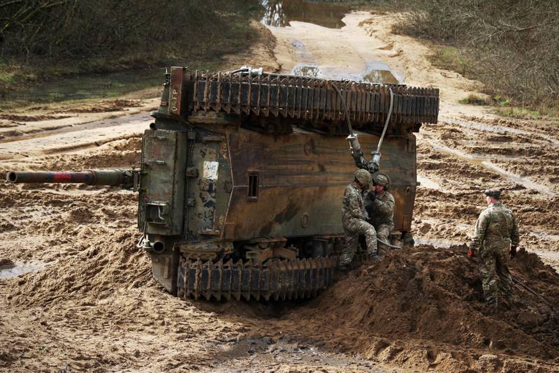 Soldiers secure cables to recover an overturned battle tank during the Royal Electrical & Mechanical Engineers’ Exercise called "Iron Challenge" in the UK. AFP