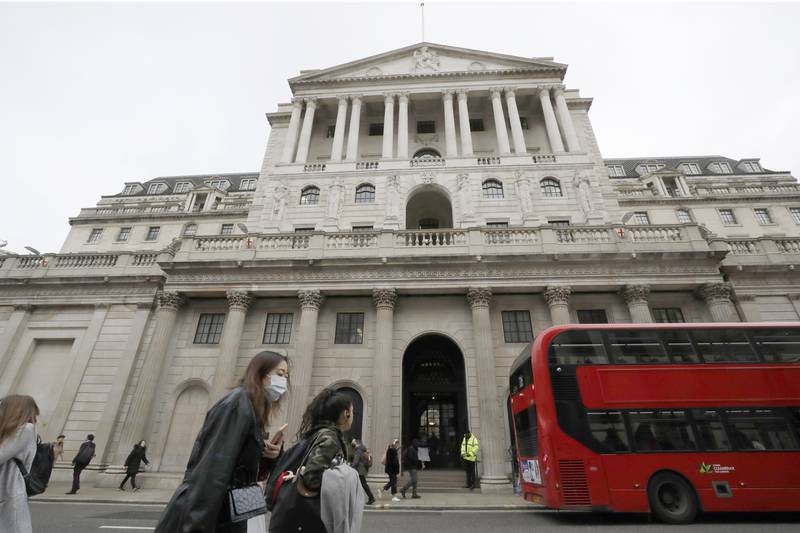Pedestrians wearing face masks pass the Bank of England in London.  The central bank reaffirmed its expectation that the economy will rebound by 7.25 per cent this year. AP