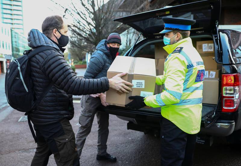 Volunteers load boxes of home test kits into a van in Woking. Reuters