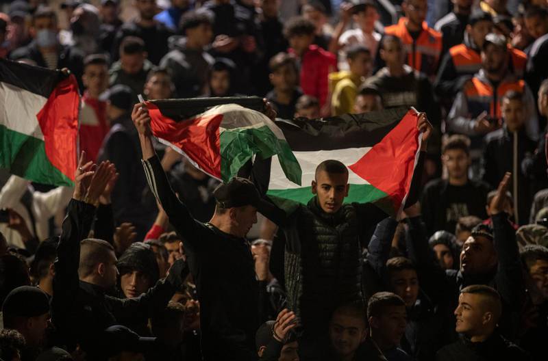Palestinians waves the Palestinian flag as they protest at Damascus Gate over police blocking off access and gathering on areas around Damascus Gate of the Old City on April 27, 2021. EPA