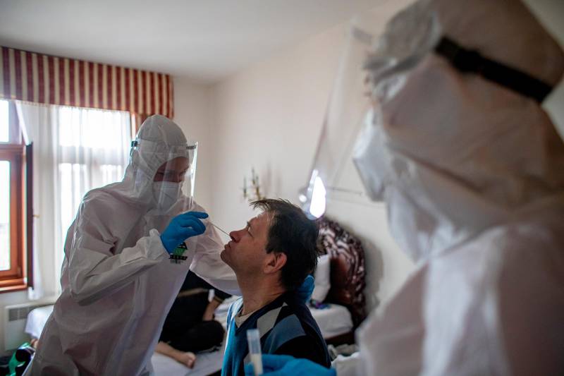 A healthcare worker removes the stitches from a homeless man in a hotel in Prague, Czech Republic. Prague is using hotels to accommodate homeless people who tested positive for coronavirus. EPA