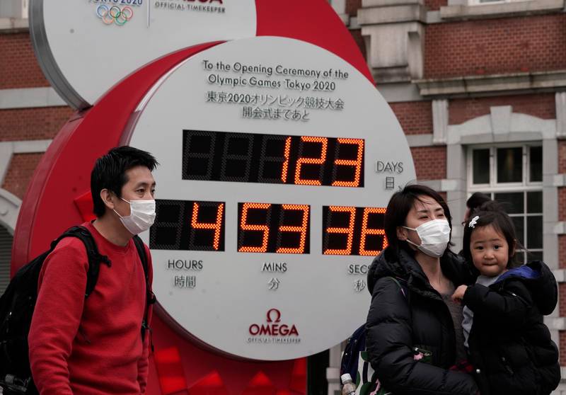 A family takes a photograph in front of a countdown clock in Tokyo. EPA