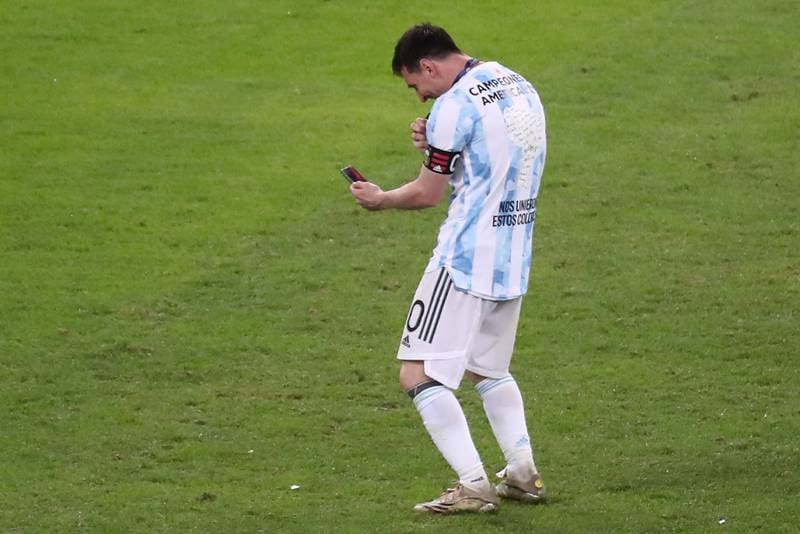 Argentina's Lionel Messi speaks on his phone as he celebrates their victory. EPA