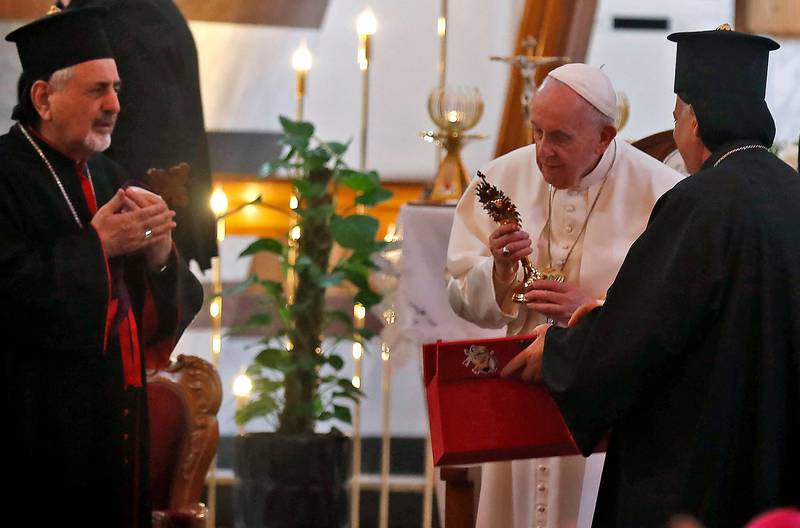 Pope Francis receives an ornamental gift after his sermon at the Our Lady of Salvation Church. AFP