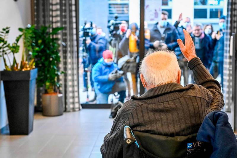 Jos Hermans, 96, who is the first to receive a Pfizer-BioNTech Covid-19 vaccine, waves to journalists in Puurs, Belgium. AFP