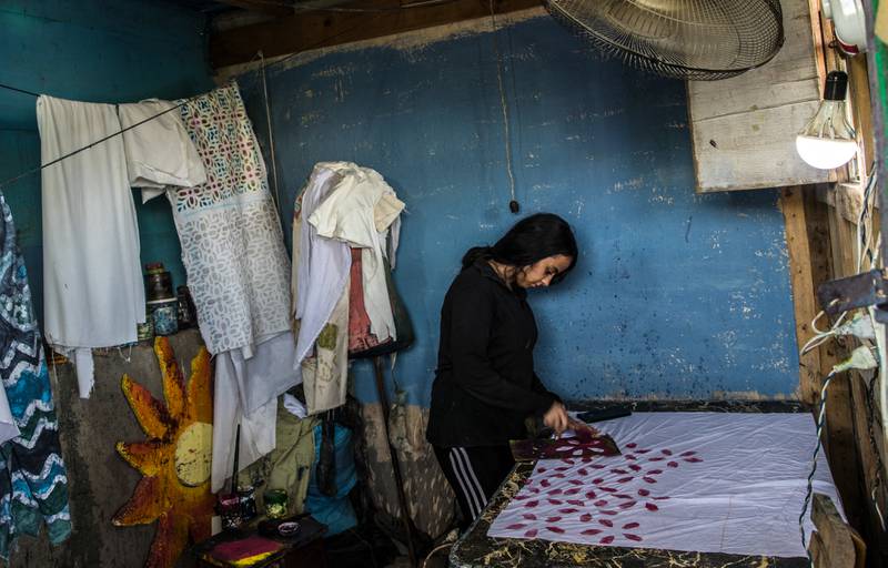 A woman applies patterns on fabric at the workshop of Egyptian batik designer Samar Hassanein in Old Cairo. AFP