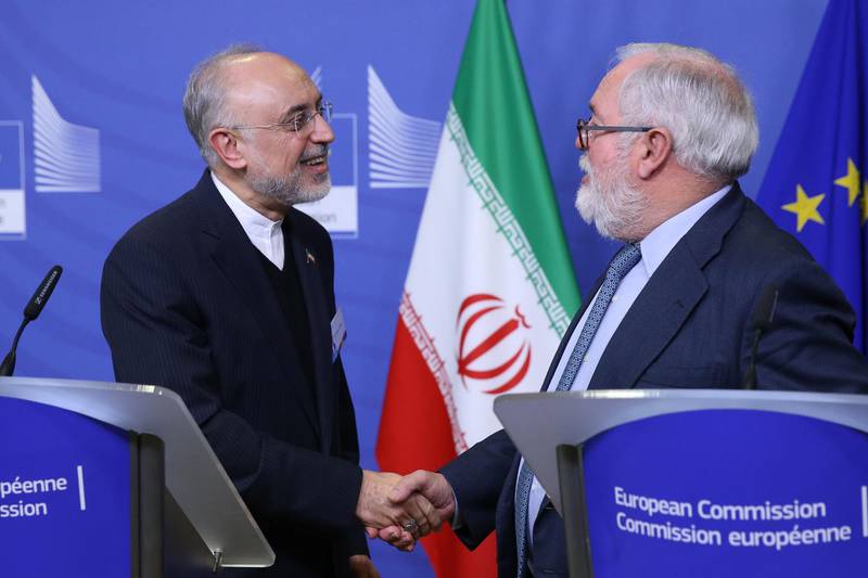 Miguel Arias Canete (R), Commissionner of the European Commission in charge of Climate Action and Energy, and Vice-President of the Islamic Republic of Iran and Head of the Atomic Energy Organisation of Iran (AEOI), Ali Akbar Salehi shake hands during a joint press point in Brussels on November 26, 2018.  / AFP / François WALSCHAERTS
