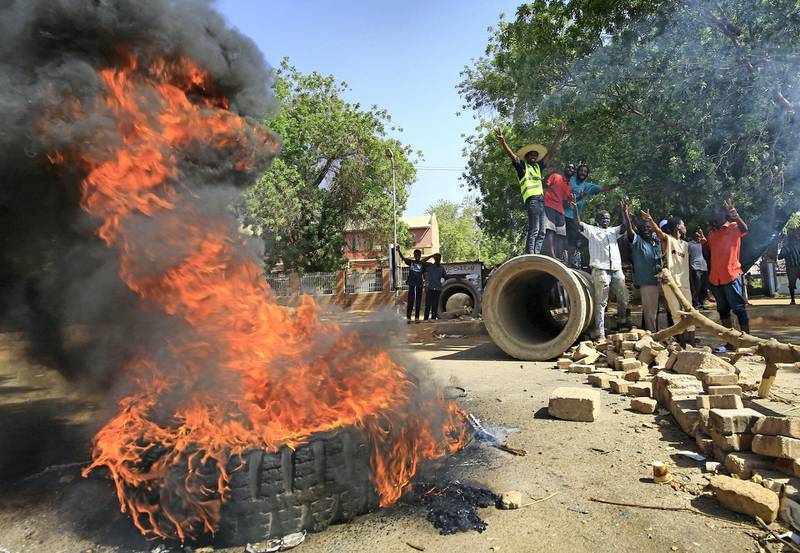 Sudanese protesters burn tyres as they block Nile Street for the second consecutive day during continuing protests in Sudan's capital Khartoum on May 13, 2019. - While angry demonstrators blocked the major avenue along the Nile river, Sudan's army rulers and protest leaders resumed crucial talks over handing power to a civilian administration after a deadlock in negotiations. The much-awaited discussions came with crowds of protesters still camped round-the-clock outside the army headquarters in central Khartoum, vowing to force the ruling military council to cede power -- just as they drove longtime leader Omar al-Bashir from office on April 11. (Photo by ASHRAF SHAZLY / AFP)
