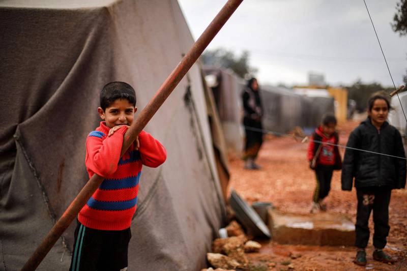 A boy looks on as he stands outside a tent at a flooded camp for displaced Syrians near the village of Killi in the north of the northwestern Idlib province.    AFP