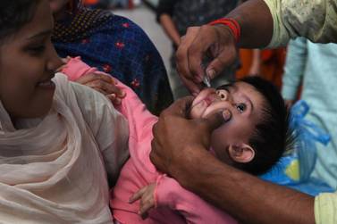 A Pakistani health worker administers polio drops to a child at a railway station during a polio vaccination campaign in Lahore on November 5, 2019. AFP