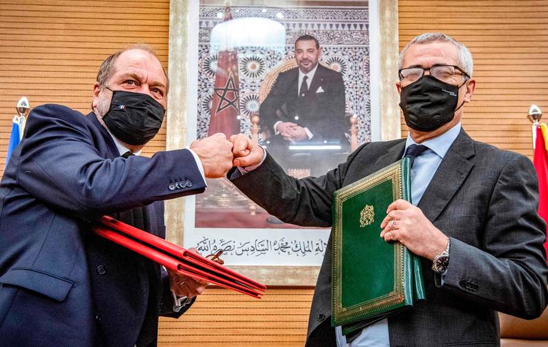 France's Justice Minister Eric Dupond-Moretti (left) fistbumps his Moroccan counterpart Mohamed Ben Abdelkader as they exchange documents in Morocco's capital Rabat.  AFP