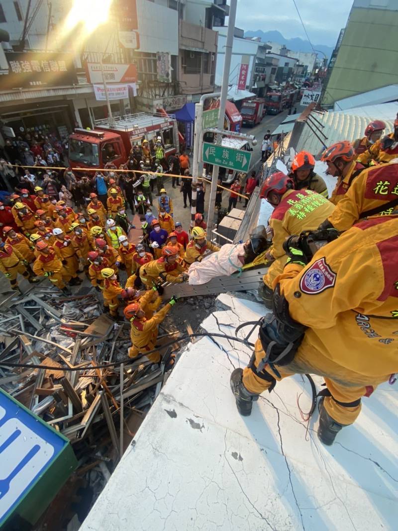 A survivor is pulled from a collapsed building. AP