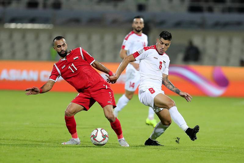 SHARJAH , UNITED ARAB EMIRATES , January  6 ��� 2019 :- Jonathan Zorrilla ( no 8 in white ) of Palestine and Osama Omari ( no 11 in red ) of Syria in action during the AFC Asian Cup UAE 2019 football match between Syria vs Palestine held at Sharjah Football Stadium in Sharjah. ( Pawan Singh / The National ) For News/Sports