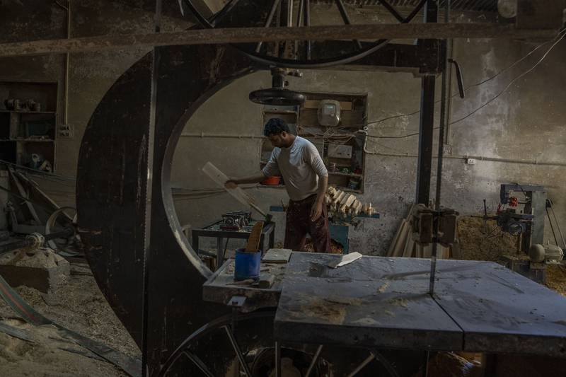 Farooq Ahmed Khan, a Kashmiri worker, prepares a cricket bat at a factory in Sangam.