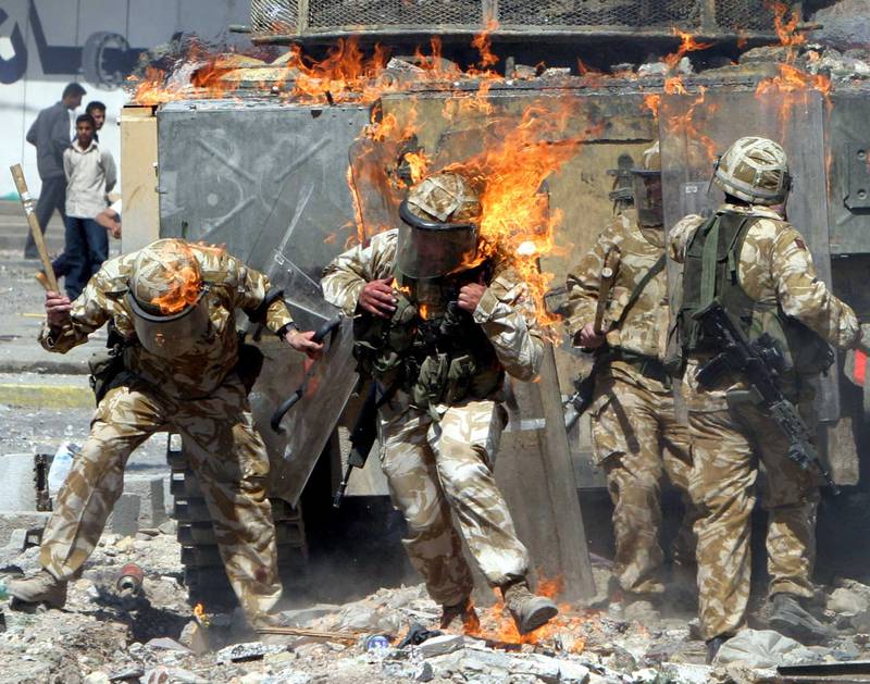 British Army troops are covered in flames from a petrol bomb thrown during a protest by job seekers in Basra in March 2004. Reuters