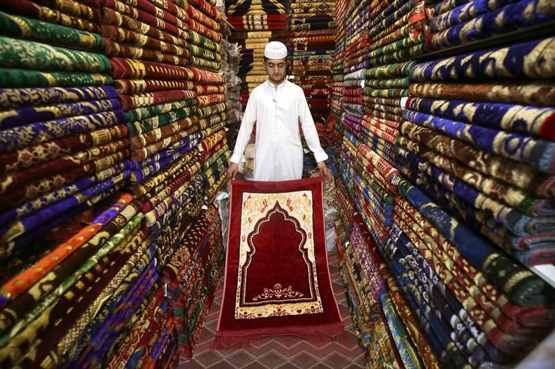 A shopkeeper sells prayer mats in Peshawar. EPA