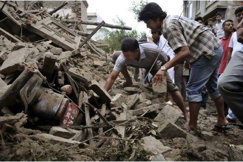 People attempt to free a motorbike buried under the debris of a house damaged by an earthquake in Bhaktapur about 14 kilometres from Katmandu, Nepal. AP Photo
