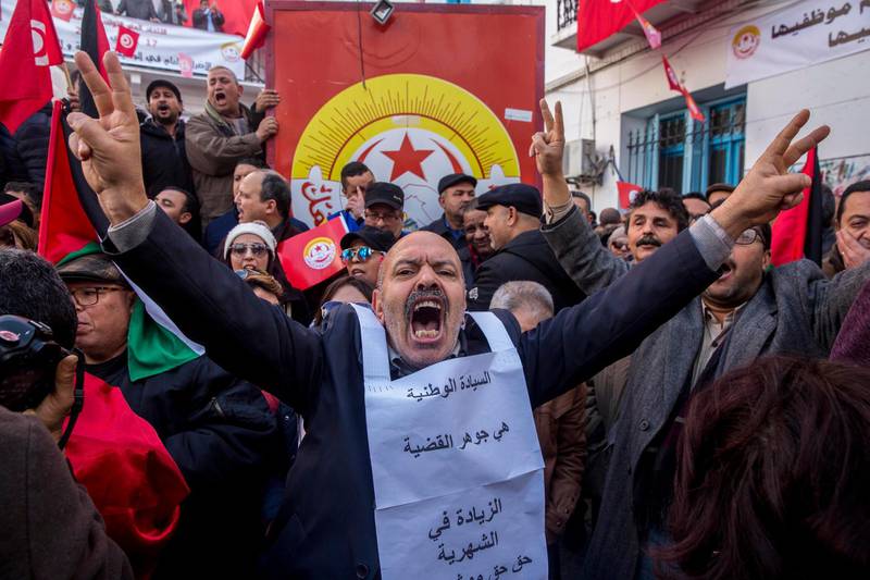 Workers stage a protest in front of the national union headquarters in Tunis. AP Photo