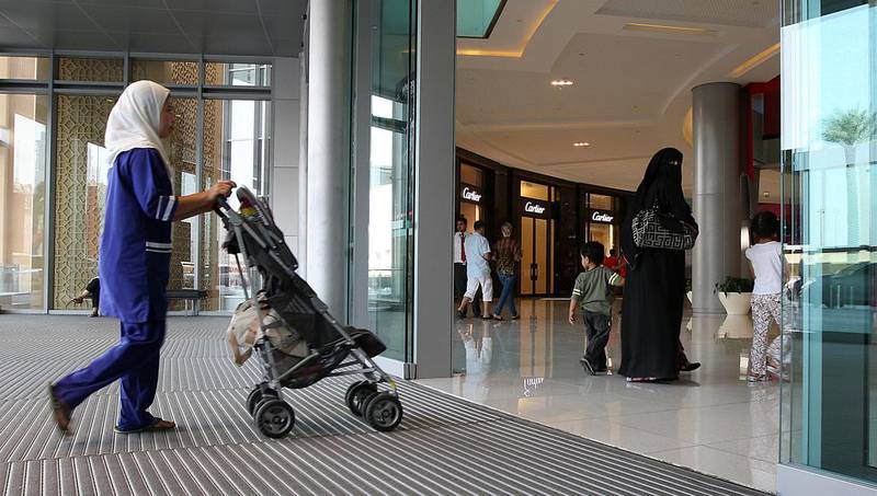A domestic worker with her employer at Dubai Mall. Pawan Singh / The National