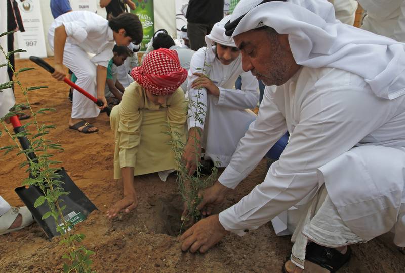 Orphans plant saplings of Ghaf trees at the heritage village in Al Shindagha to commemorate Zayed Humanitarian Day. Jeffrey E Biteng / The National