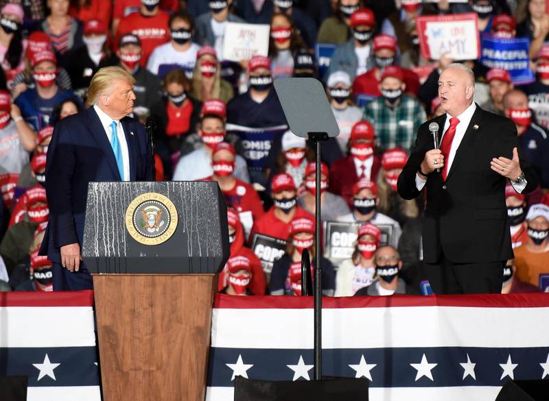 US President Donald Trump, left, listens to Patrick Yoes, national president of the Fraternal Order of Police, speak during a Trump campaign rally at Harrisburg International Airport. AP Photo