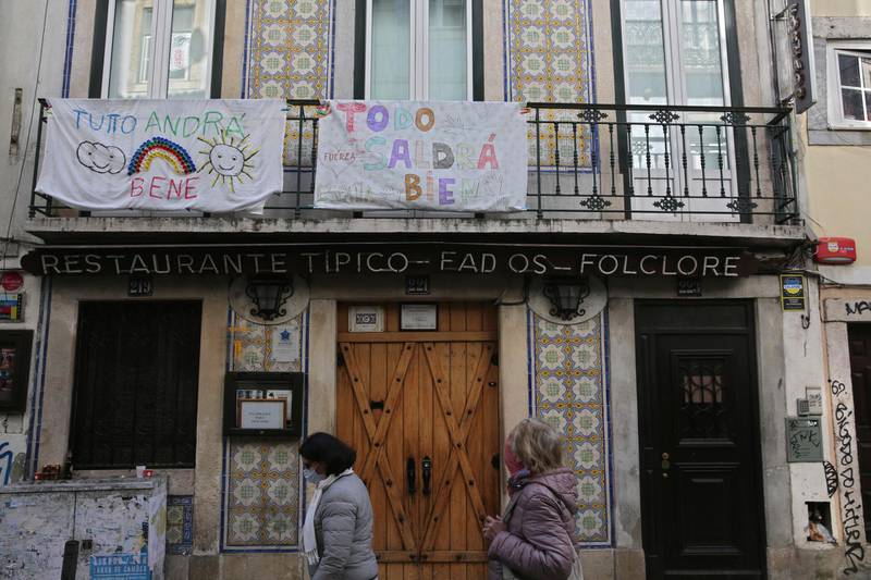 Banners in Italian and Spanish hang from balconies above a closed fado restaurant in Lisbon's Bairro Alto neighborhood. AP