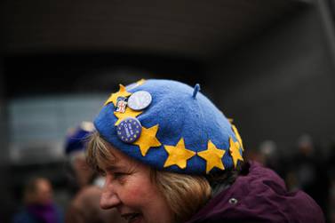 An anti-Brexit campaigner wears a hat with the EU stars and pins during a demonstration outside the European Parliament in Brussels, Thursday, Jan. 23, 2020. (AP Photo/Francisco Seco)