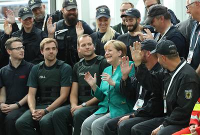 German chancellor Angela Merkel sits with members of law enforcement and emergency services while thanking them at the conclusion of the G20 economic summit on July 8, 2017 in Hamburg, Germany. Severe rioting by anti-G20 activists that included looting, arson and attacks on police overshadowed the two-day summit. Sean Gallup / Getty Images