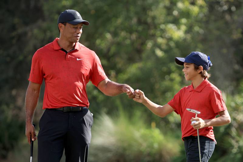 Tiger and Charlie celebrate a birdie on the 12th hole. AFP