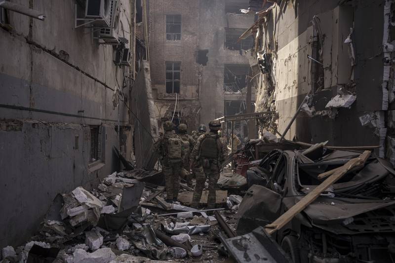 Ukrainian servicemen walk among debris of damaged buildings after a Russian attack in Kharkiv, Ukraine. AP