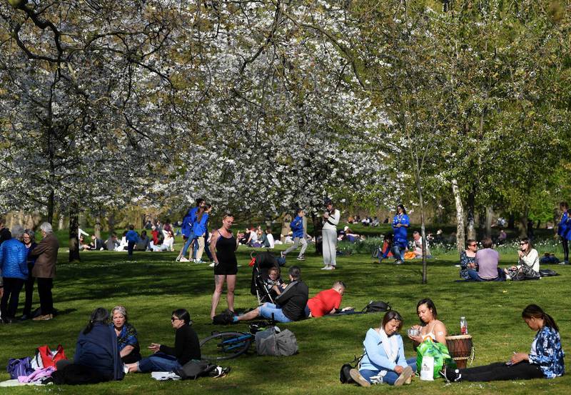 People relax in the sunshine, as lockdown restrictions are eased, in St. James's Park, London. Reuters