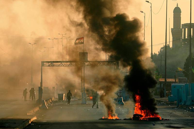 Iraqi security forces fire tear gas to disperse anti-government protesters during a demonstration in Baghdad, Iraq. AP