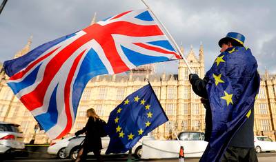 (FILES) In this file photo taken on March 28, 2018 An anti-Brexit demonstrator waves a Union flag alongside a European Union flag outside the Houses of Parliament in London. The British government said on September 7, 2020, that it was taking steps to "clarify" how Northern Ireland's trade will be handled after Brexit, but insisted it remained committed to its EU withdrawal agreement and the province's peace process. Britain cannot allow the peace process or its internal market "to inadvertently be compromised by unintended consequences" of the Brexit protocol relating to Northern Ireland, Prime Minister Boris Johnson's official spokesman said.
 / AFP / Tolga AKMEN
