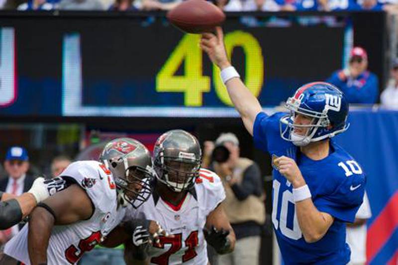 New York Giants' Eli Manning looks for a throw after coming under pressure from Tampa Bay Buccaneers' Gerald McCoy and Michael Bennett