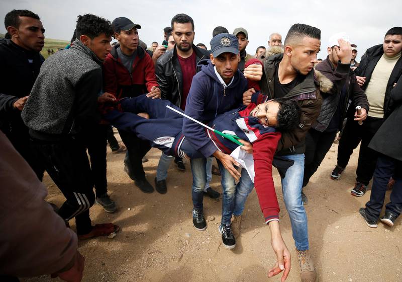 A wounded Palestinian is carried away during clashes with Israeli troops east of Gaza City on March 30, 2018. Mohammed Salem / Reuters