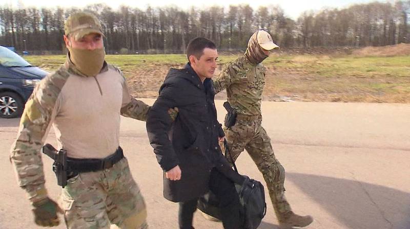 Former US  Marine Trevor Reed is escorted to a plane by Russian service members as part of a prisoner swap between the US and Russia. Handout via Reuters 
