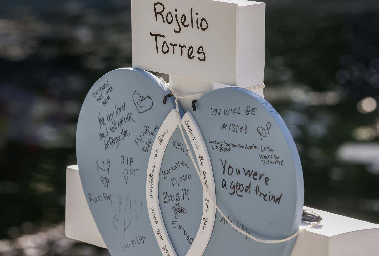 People leave flowers and sign messages on crosses bearing the names of victims in the city park following the mass shooting at the Robb Elementary School in Uvalde, 26 May. EPA