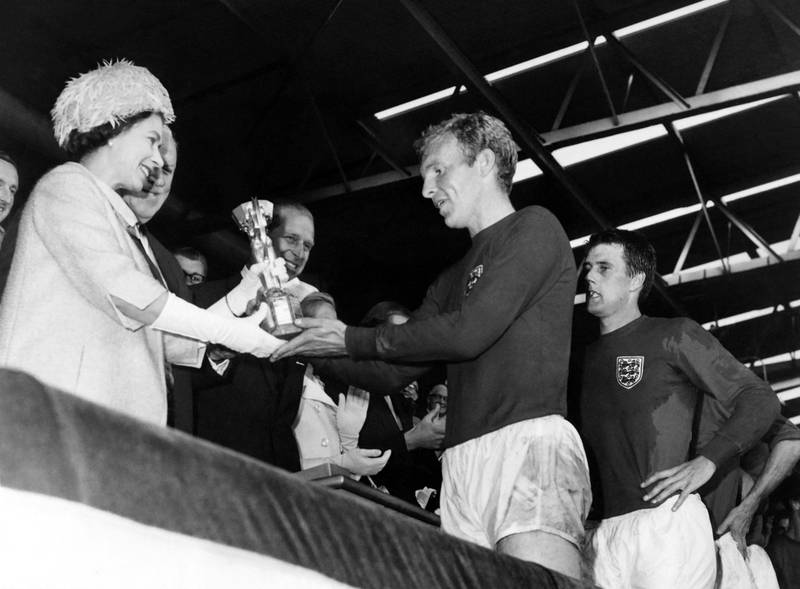 Queen Elizabeth II presents the Jules Rimet Trophy to England captain Bobby Moore after their victory over West Germany in the 1966 World Cup final at Wembley Stadium. AFP