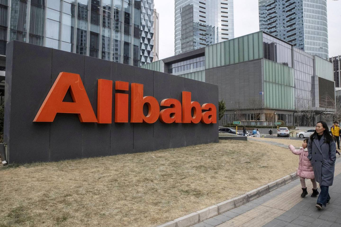 People walk past the Alibaba Group Holdings Ltd. signage displayed outside the company's Beijing office in Beijing, China, on Wednesday, Jan. 30, 2019. Alibaba is scheduled to release its third-quarter earnings figures on Jan. 30. Photographer: Gilles Sabrie/Bloomberg