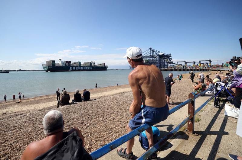 Spectators watch as the container ship Ever Given arrives at the Port of Felixstowe Ltd.  in Felixstowe, U. K. , on Tuesday, Aug.  3, 2021.  The giant container ship that had blocked Egypt’s Suez Canal for nearly a week earlier this year was released on July 7 following an agreement between authorities and the vessel’s owners. Photographer: Chris Ratcliffe / Bloomberg